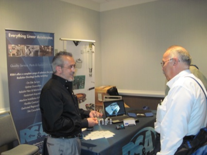 Bill Ginas (L) of RS&A with meeting attendee